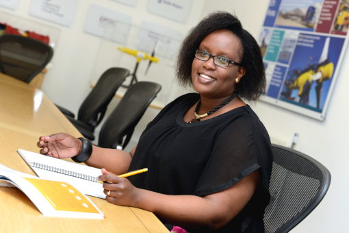 Dr Inès Tunga sitting in an office environment with pen and paper