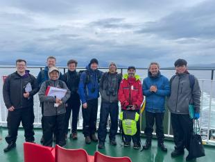 A small group of students on the deck of a ferry at sea