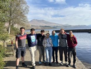 IDCORE Research Engineer - Josh Mitchell with cohort colleagues IDCORE Research Engineer - Josh Mitchell with a small group of colleagues next to a small harbour