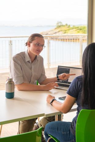 Fred and colleague discussing work displayed on a laptop