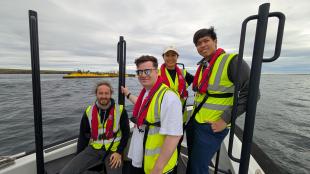 IDCORE Research Engineer - Liam McAlister with cohort colleagues IDCORE Research Engineer - Liam McAlister with a small group of colleagues on a boat at sea
