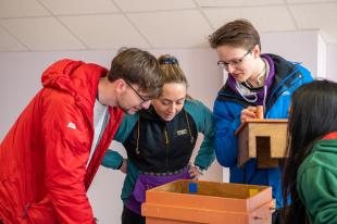 Group shot of ICDORE students looking in a box