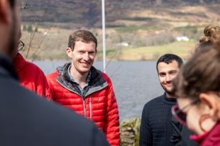 IDCORE students talking in the sunshine by a sea loch