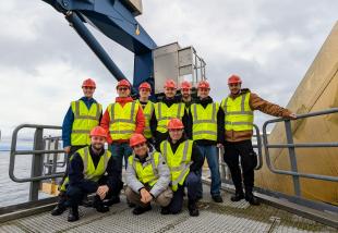 A group of 10 IDCORE students standing on a turbine Transitions Piece