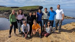 Tara Alkubaisi with IDCORE students on top of sea cliffs in Orkney