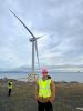 IDCORE Research Engineer - Nikitas Fotiou standing in front of a wind turbine