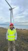 IDCORE Research Engineer - Yusril Fatahilmi with a wind turbine in the background